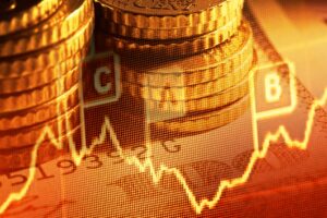 Pile di monete sovrapposte a un grafico di borsa fluttuante e a dati finanziari, che simboleggiano investimenti, crescita economica o analisi di mercato. L'immagine ha una tonalità calda e dorata.