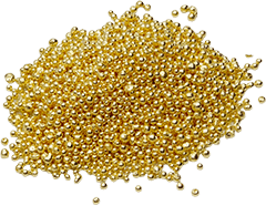 Un mucchio di piccole perline dorate e lucenti è sparso su uno sfondo bianco.