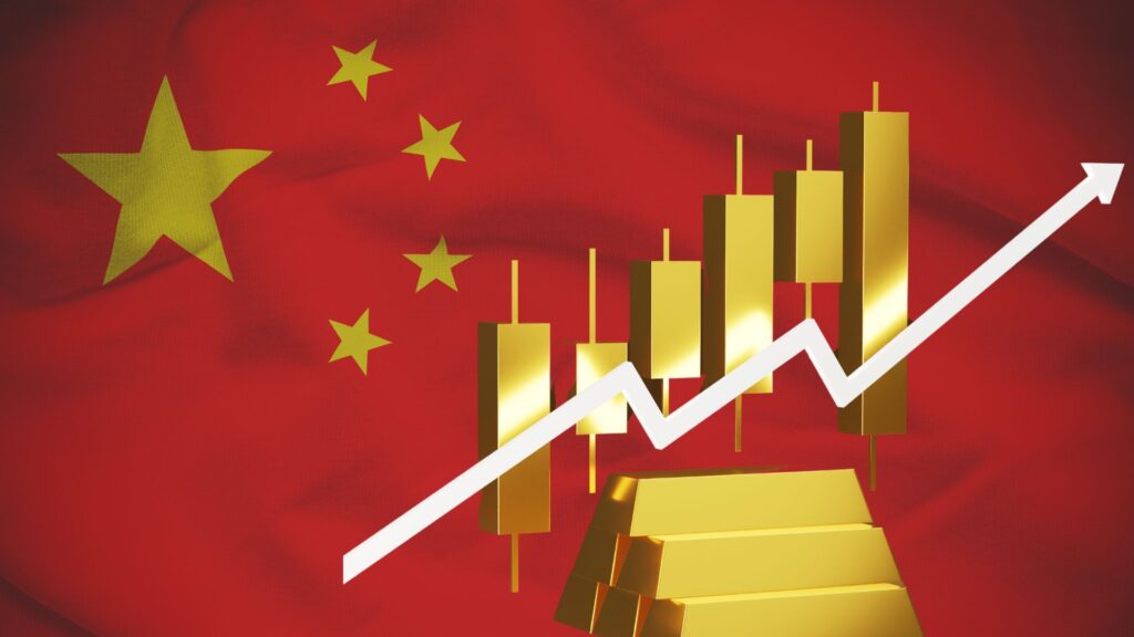 Una bandiera cinese sullo sfondo, con lingotti d'oro, un grafico a candele e una freccia bianca rivolta verso l'alto in primo piano, simbolo di crescita economica o finanziaria.