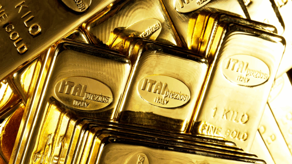 Pile di lingotti d'oro lucidi, ciascuno del peso di un chilogrammo, con la scritta ITALPREZIOSI ITALIA 1 KILO FINE GOLD impressa sulla superficie. I lingotti sono disposti in modo ravvicinato e riflettono la luce dorata.