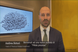 Un uomo in giacca e cravatta si trova al chiuso e parla alla telecamera. Un testo sullo schermo lo presenta come Andrea Sirtori, responsabile degli investimenti in metalli preziosi. Alle sue spalle un monitor mostra una pila di oggetti d'argento.