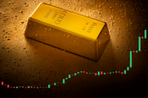 Un lingotto d'oro con la dicitura 999.9 FINE GOLD 1000g si trova su una superficie d'oro testurizzata, con un grafico a candele ascendente sovrapposto, che rappresenta l'aumento del prezzo dell'oro.