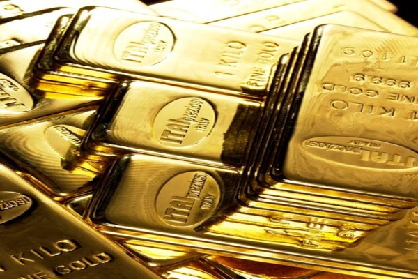 Una vista ravvicinata di diversi lingotti d'oro lucidi impilati l'uno sull'altro, ciascuno etichettato con 1 KILO e recante marcature che ne indicano il peso e la purezza. I lingotti hanno una superficie riflettente e lucente.