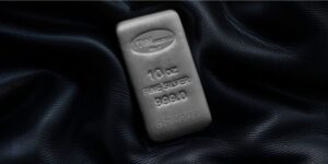 Un lingotto d'argento da 10 once con la dicitura 10 oz FINE SILVER 999.0 poggia su un tessuto scuro e strutturatto. Il lingotto riporta il marchio di Italpreziosi.