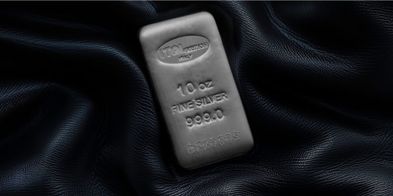 Un lingotto d'argento da 10 once con la dicitura 10 oz FINE SILVER 999.0 poggia su un tessuto scuro e strutturatto. Il lingotto riporta il marchio di Italpreziosi.